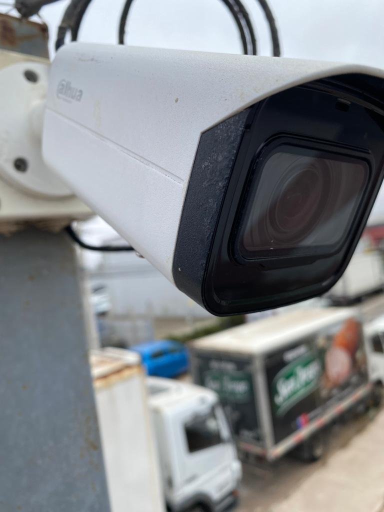 Cámara de seguridad vigilando un andén de carga con camiones de reparto